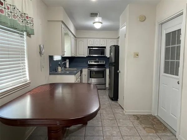 a view of kitchen with stainless steel appliances granite countertop a stove a refrigerator and a sink