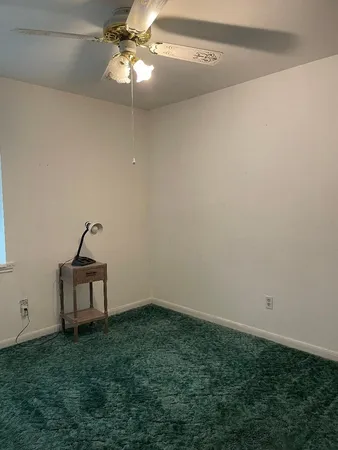 a view of a room with a fan and a window