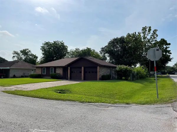 a view of a big house with a big yard and a large trees