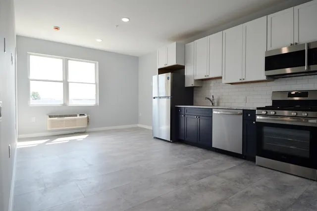 a kitchen with stainless steel appliances a refrigerator stove and microwave