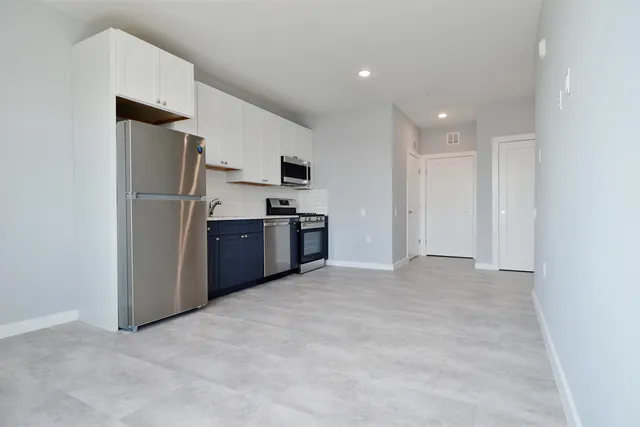 a view of kitchen with refrigerator and microwave