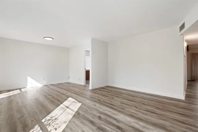 a view of an empty room and wooden floor