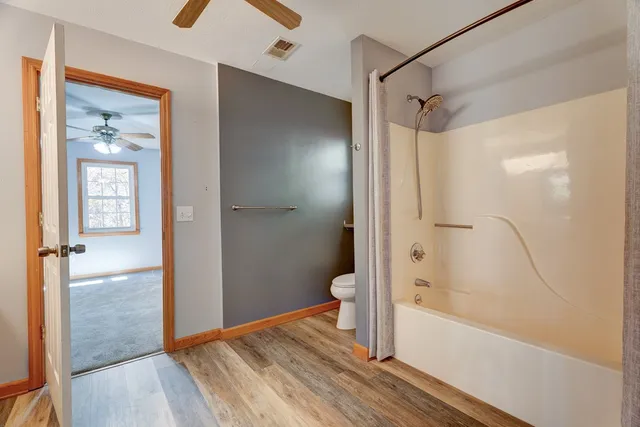 a white toilet sitting next to a bath tub