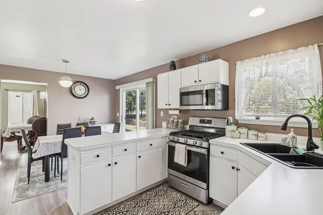 a kitchen with stainless steel appliances a stove a sink and a microwave