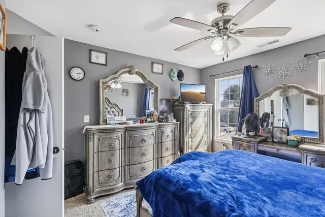 a bedroom with a bed dresser and a large mirror