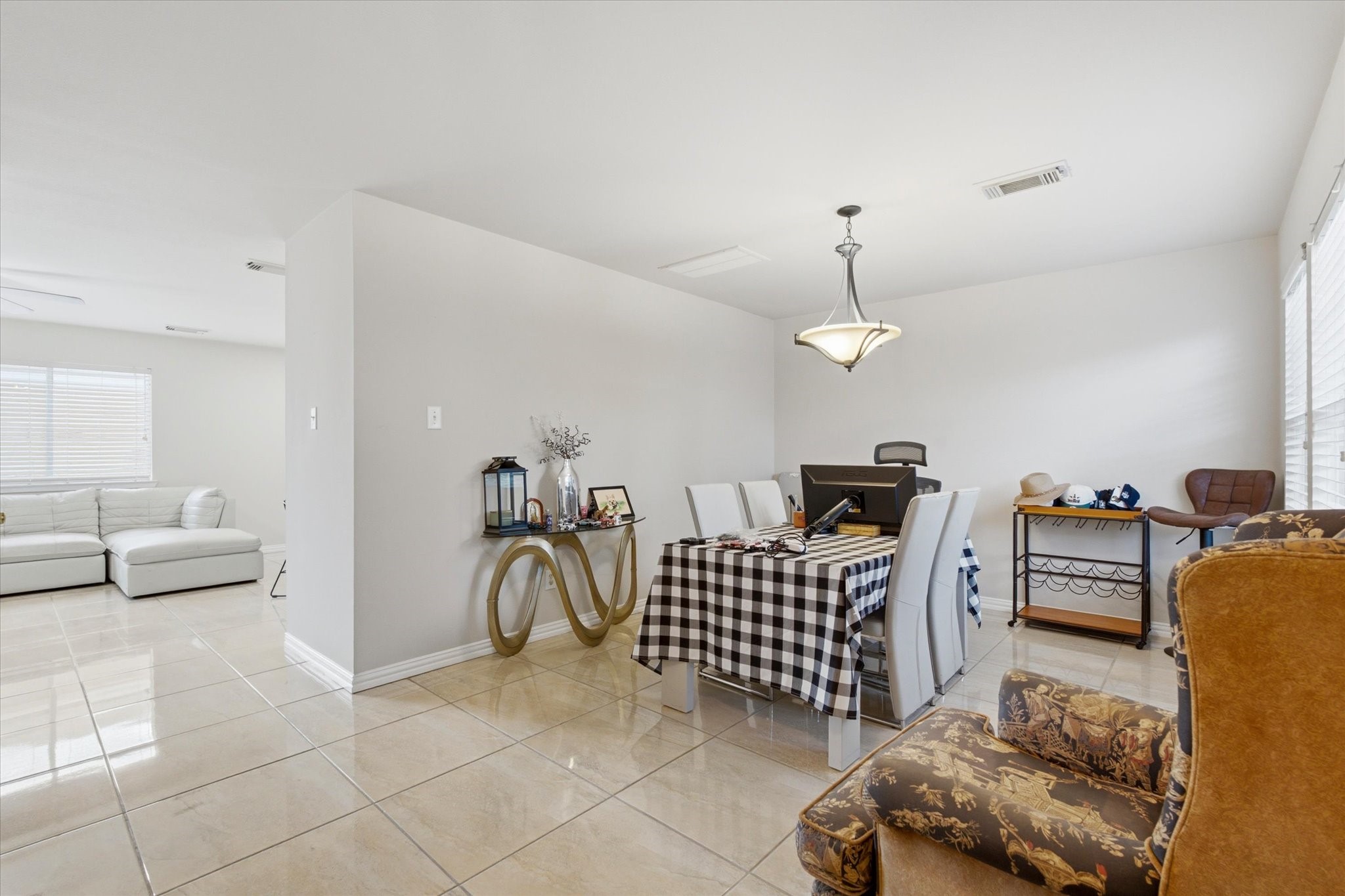 3946 Mossy Pl Lane Spring, TX 77388 - Photo 2 of 17 Step inside to an open dining space, finished with polished tile flooring and neutral-toned walls. The room easily accommodates a full-size dining set and features a classic hanging light fixture.