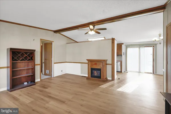 a view of an empty room with a fireplace and a window