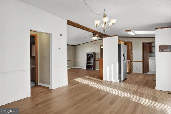 a view of a livingroom with a chandelier fan front door and fire place