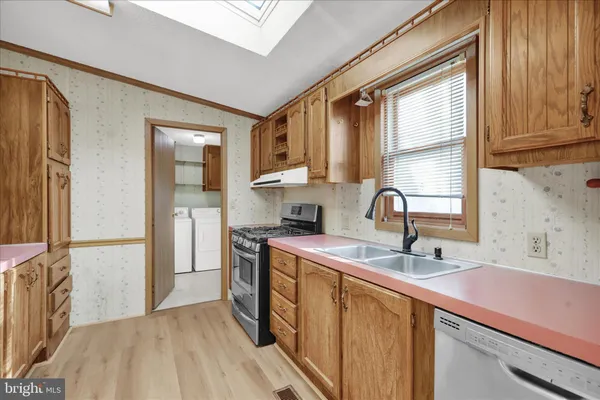 a kitchen with stainless steel appliances granite countertop a sink a stove and a refrigerator