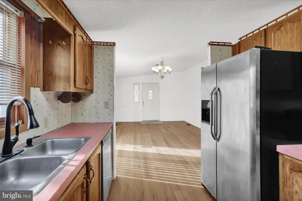 a kitchen with kitchen island granite countertop a sink and refrigerator