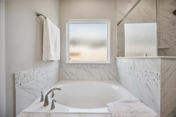 a bathroom with a bathtub and a window