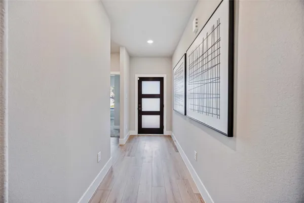 a view of a hallway with wooden floor and windows