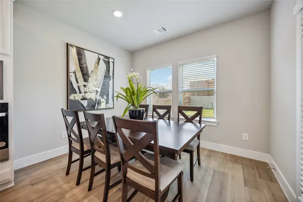 a dining room with furniture and wooden floor