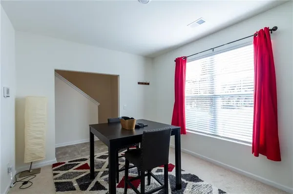 a view of a workspace with furniture and a window