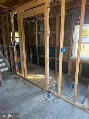 a view of an empty room with wooden floor and a fireplace