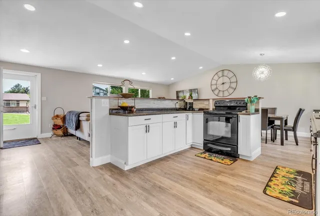 a kitchen with stainless steel appliances granite countertop a stove and a wooden floors