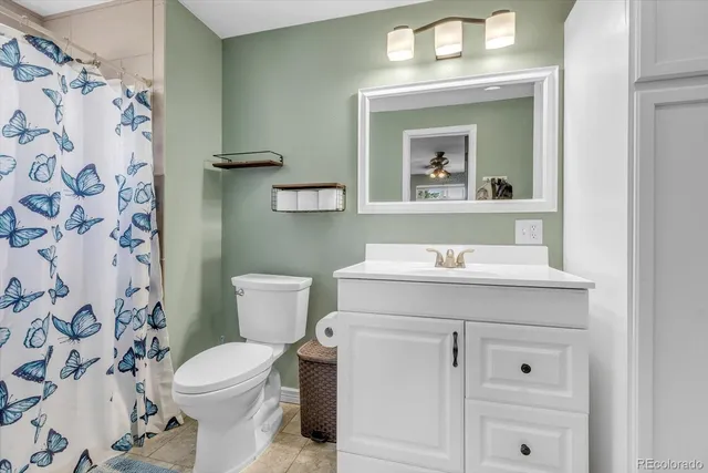 a bathroom with a sink vanity mirror and toilet