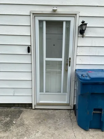 a view of a house with a door and a wooden bench