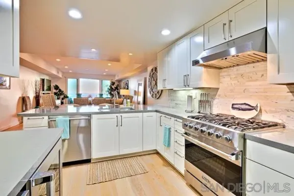 a kitchen with stainless steel appliances a stove a sink and a refrigerator