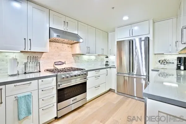 a kitchen with granite countertop white cabinets and stainless steel appliances