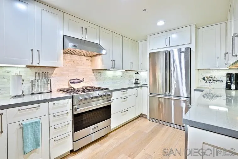 6767 Neptune Place, Unit 202 La Jolla, CA 92037 - Photo 13 of 27 a kitchen with granite countertop white cabinets and stainless steel appliances