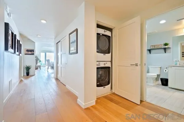 a view of a hallway with wooden floor and a living room