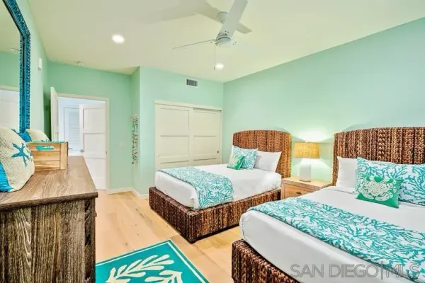 a bedroom with two beds and a dresser