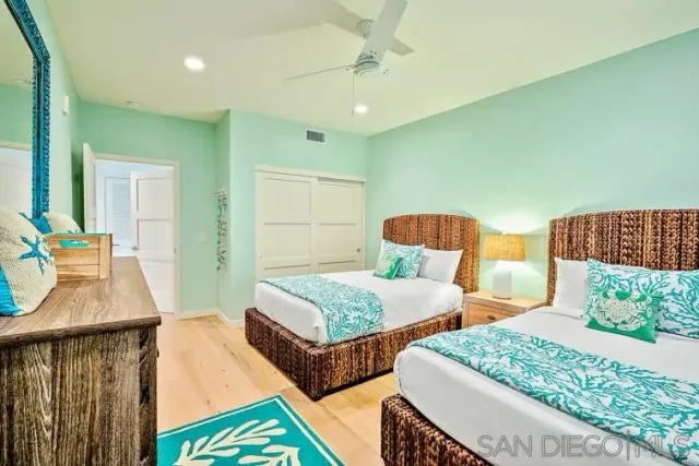 a bedroom with two beds and a dresser