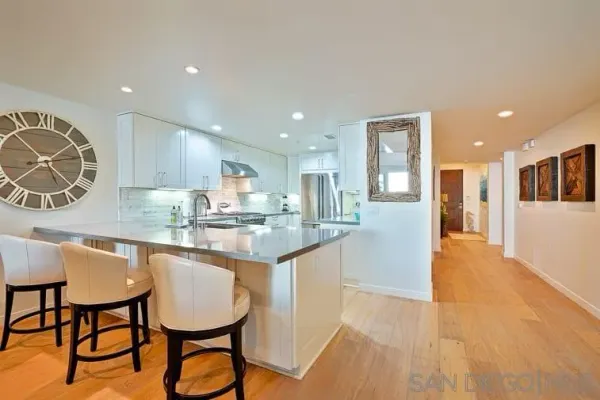 a kitchen with stainless steel appliances granite countertop a kitchen island a table and chairs in it
