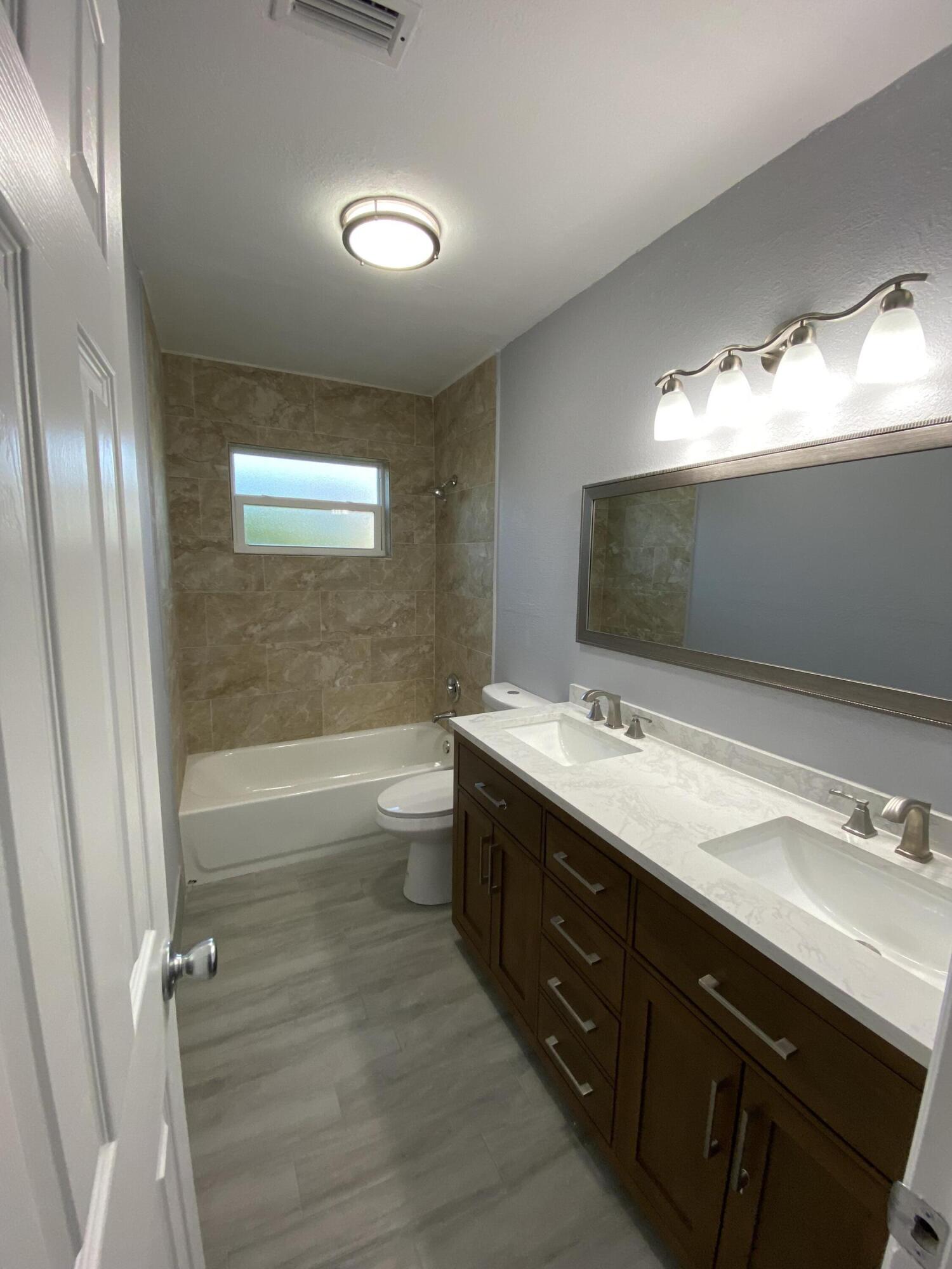 232 Northwest 9th Street Pompano Beach, FL 33060 - Photo 12 of 46 a bathroom with a double vanity sink and a mirror