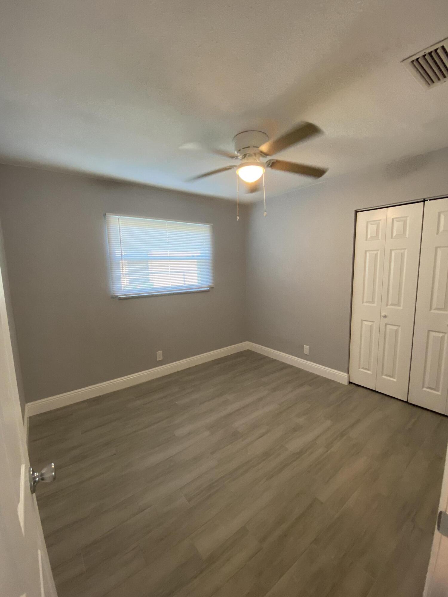 232 Northwest 9th Street Pompano Beach, FL 33060 - Photo 15 of 46 an empty room with a chandelier fan and windows