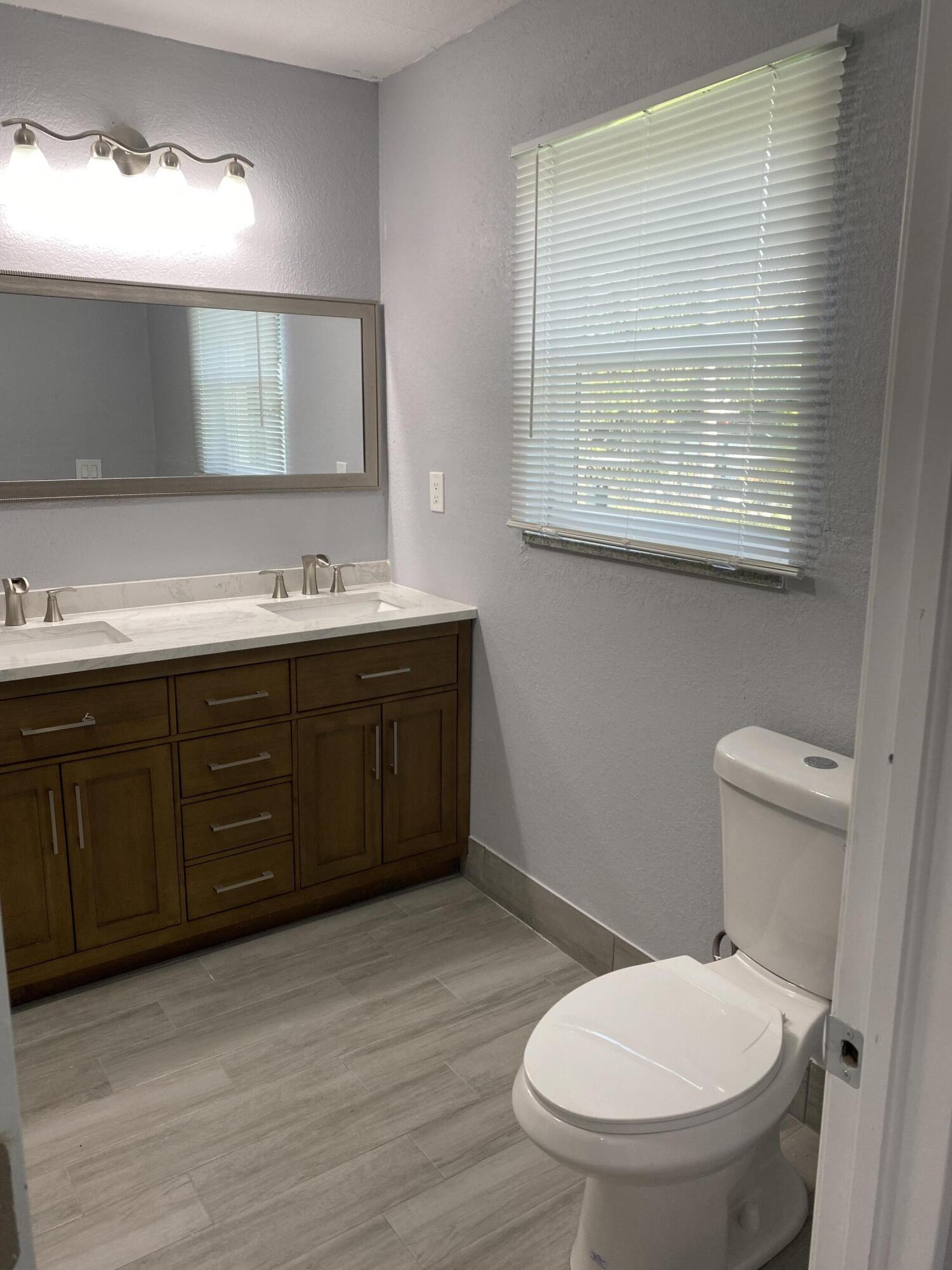 232 Northwest 9th Street Pompano Beach, FL 33060 - Photo 25 of 46 a bathroom with a toilet a sink and mirror