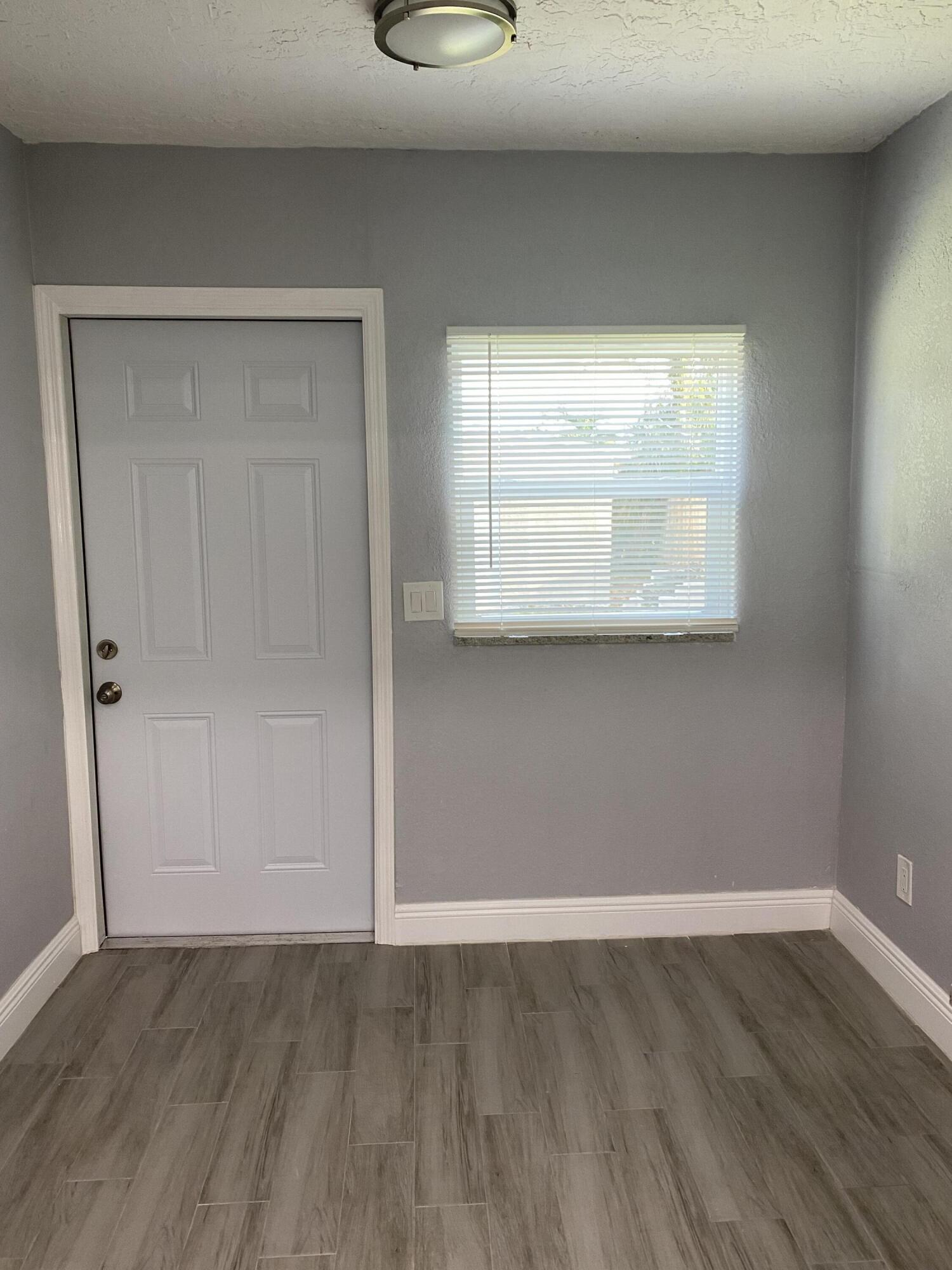 232 Northwest 9th Street Pompano Beach, FL 33060 - Photo 31 of 46 a view of an empty room with wooden floor and a window