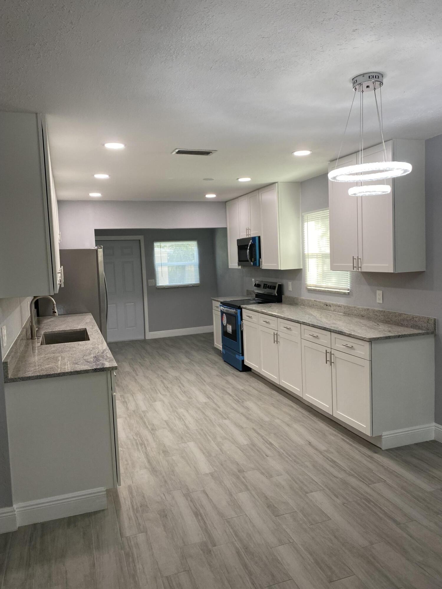 232 Northwest 9th Street Pompano Beach, FL 33060 - Photo 33 of 46 a kitchen with granite countertop a sink and a stove top oven