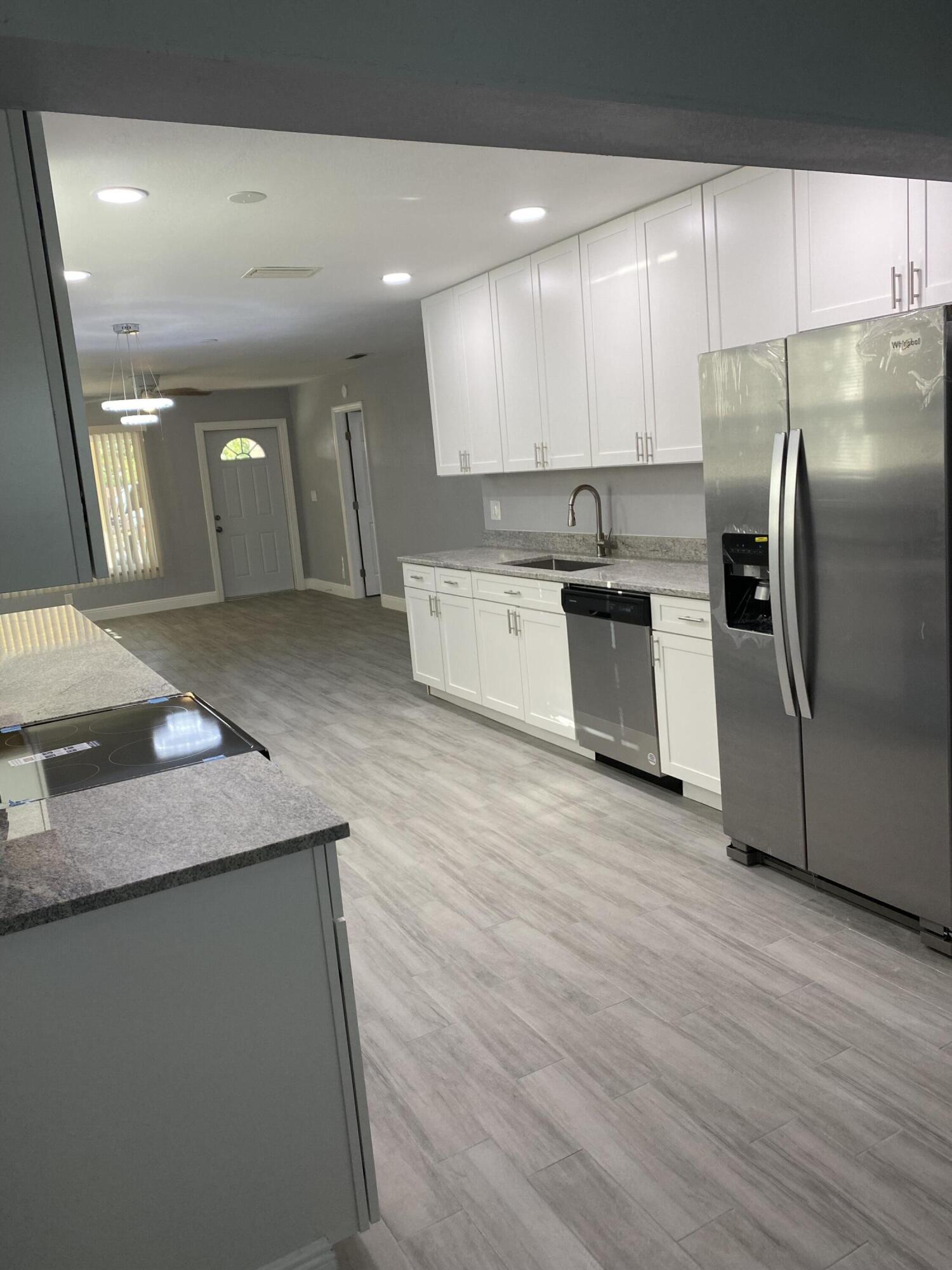 232 Northwest 9th Street Pompano Beach, FL 33060 - Photo 38 of 46 a large kitchen with stainless steel appliances kitchen island a large counter top and a wooden floors