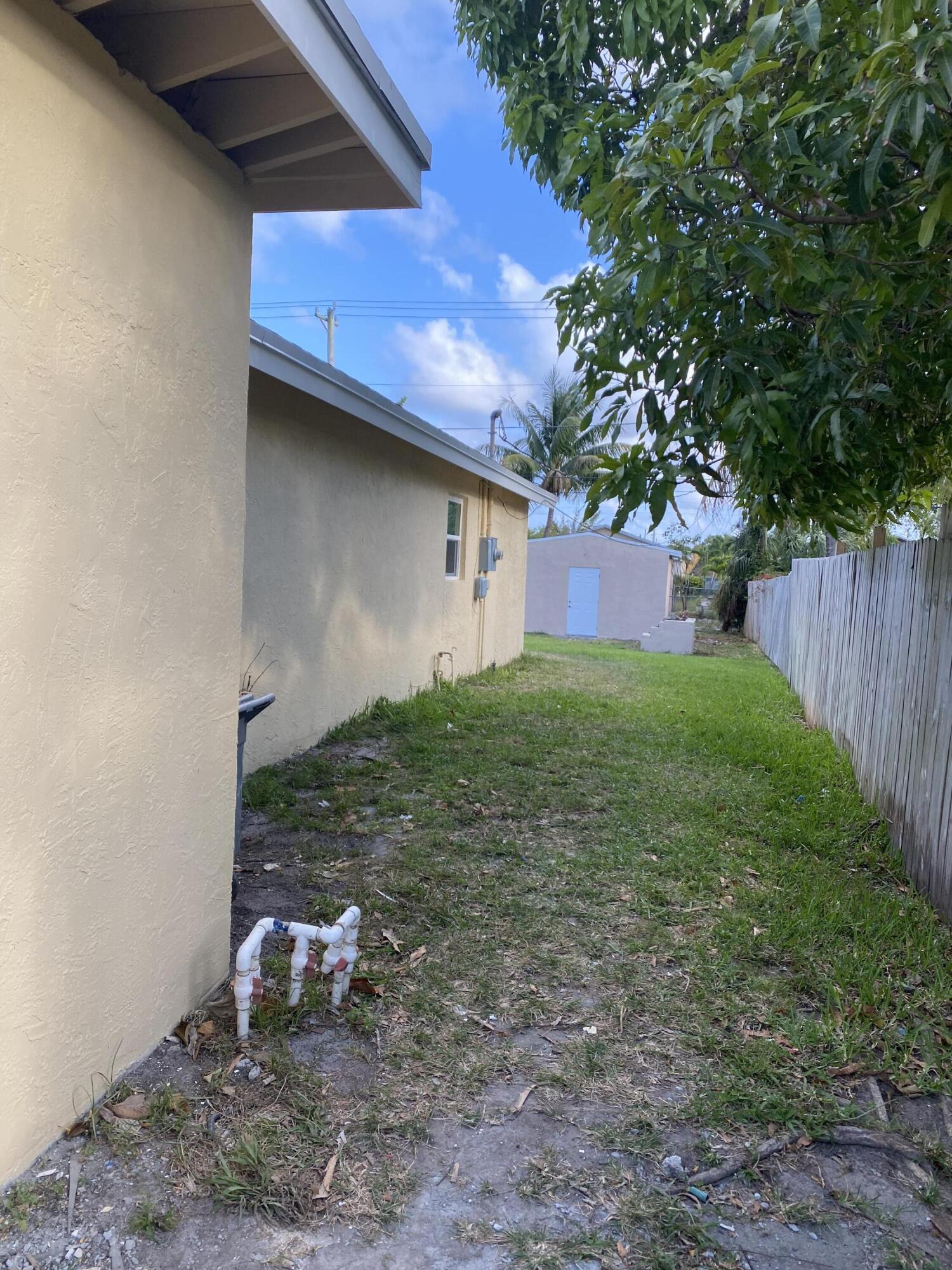 232 Northwest 9th Street Pompano Beach, FL 33060 - Photo 4 of 46 a backyard of a house with table and chairs