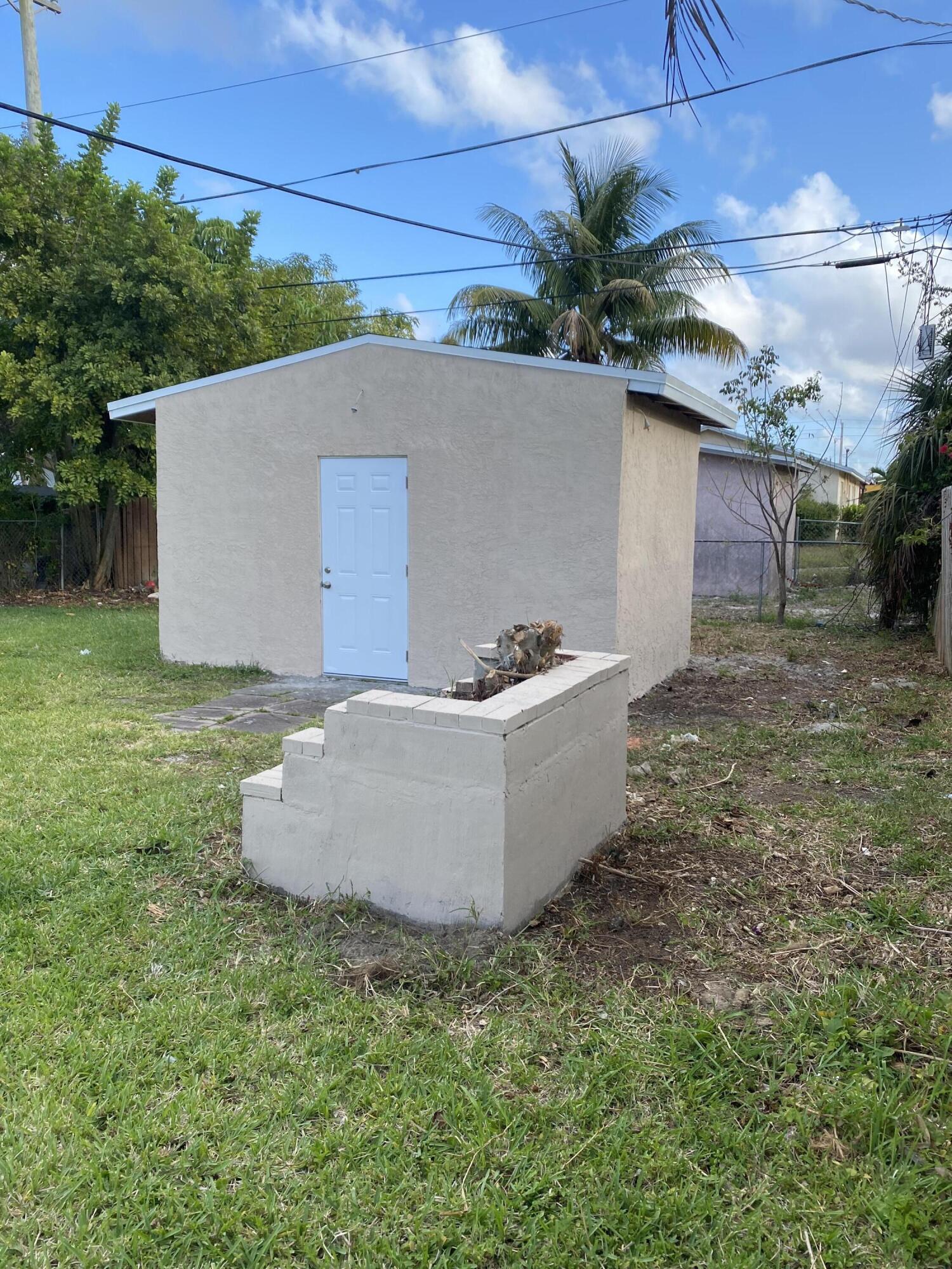 232 Northwest 9th Street Pompano Beach, FL 33060 - Photo 42 of 46 front view of a house with a yard and a tub