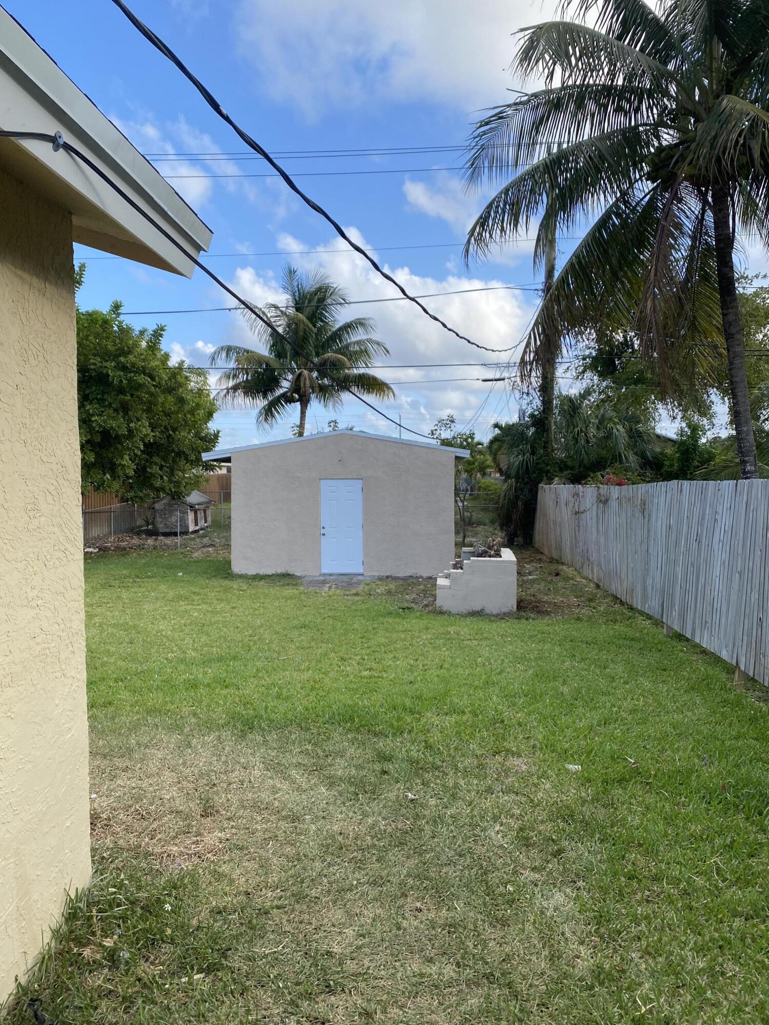 232 Northwest 9th Street Pompano Beach, FL 33060 - Photo 6 of 46 a view of a house with a yard and a garage