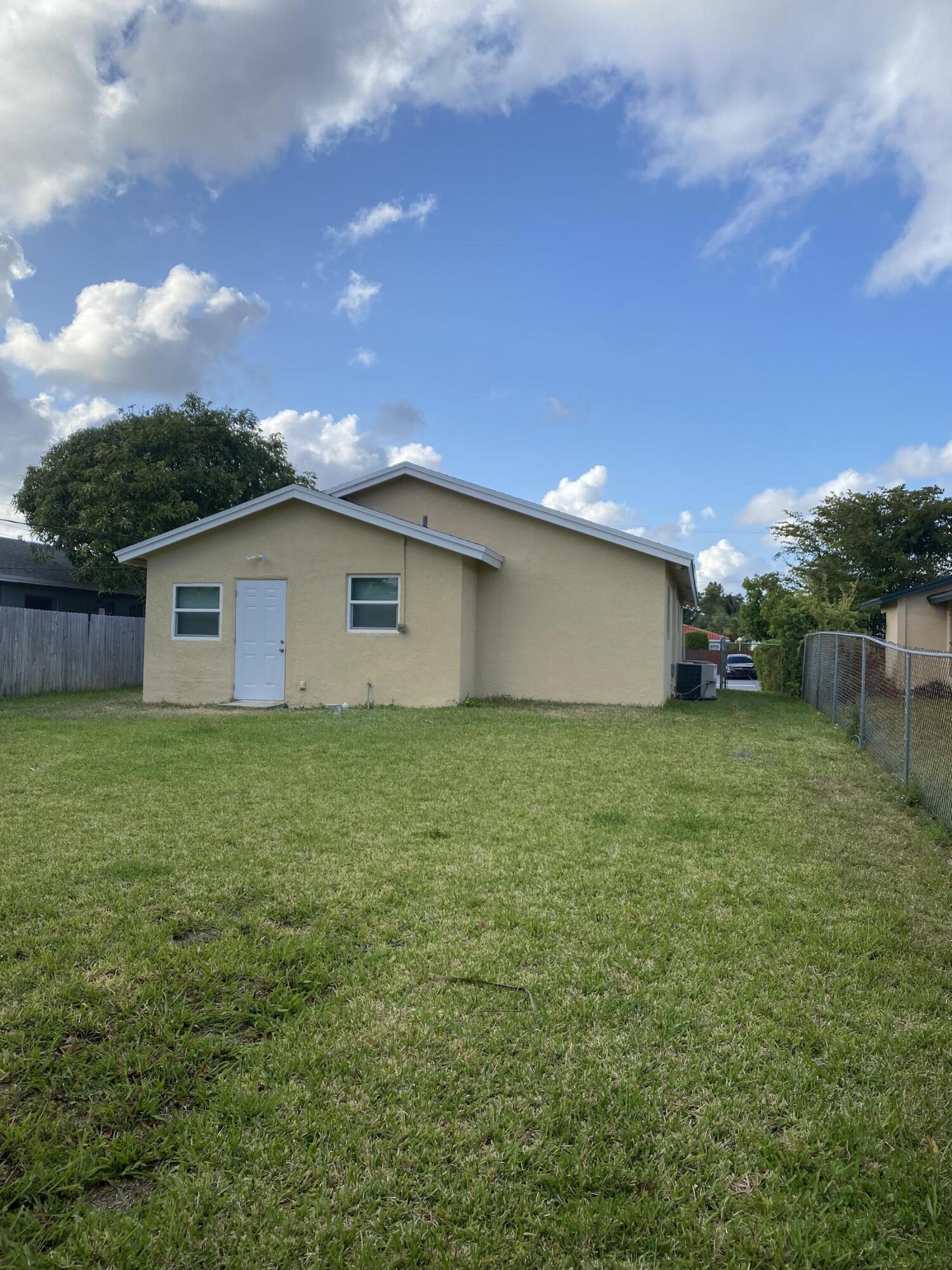 232 Northwest 9th Street Pompano Beach, FL 33060 - Photo 7 of 46 a view of a backyard with potted plants and a large tree