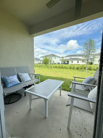 a view of a patio with lawn chairs next to a yard
