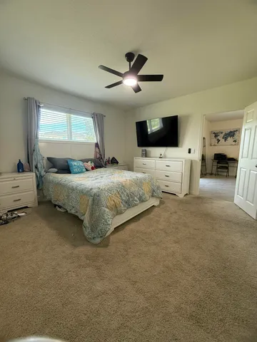 a spacious bedroom with a bed and a flat screen tv