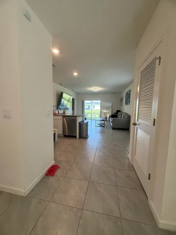 a living room with furniture and a refrigerator