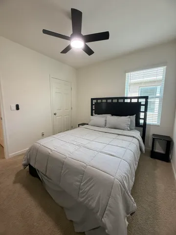 a bedroom with a bed and a ceiling fan