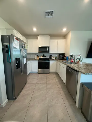 a kitchen with stainless steel appliances granite countertop a stove a sink dishwasher a refrigerator and a oven