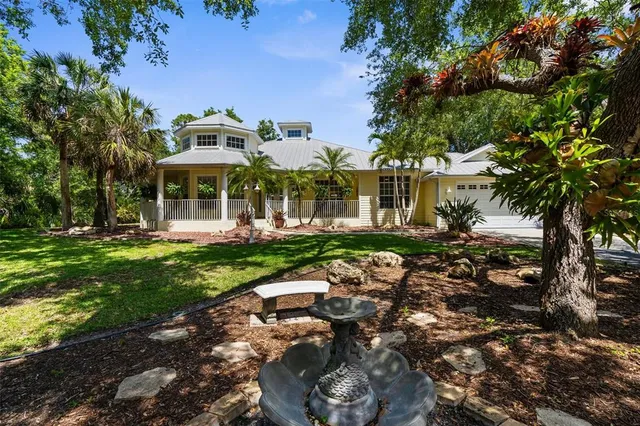 a view of a house with a yard and potted plants