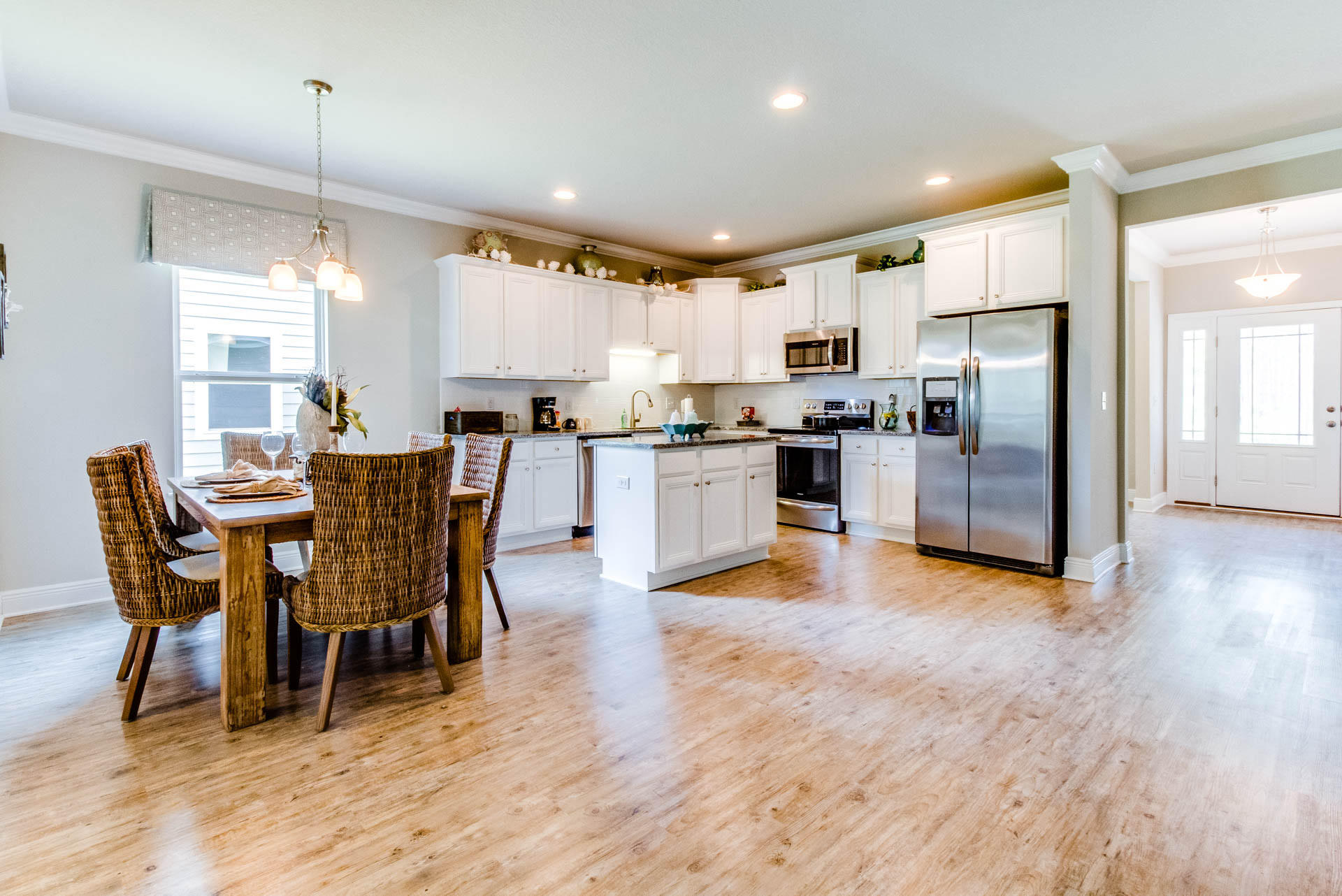 219 Southern Pnes Road Santa Rosa Beach, FL 32459 - Photo 7 of 28 a kitchen with stainless steel appliances kitchen island granite countertop a table chairs and a refrigerator