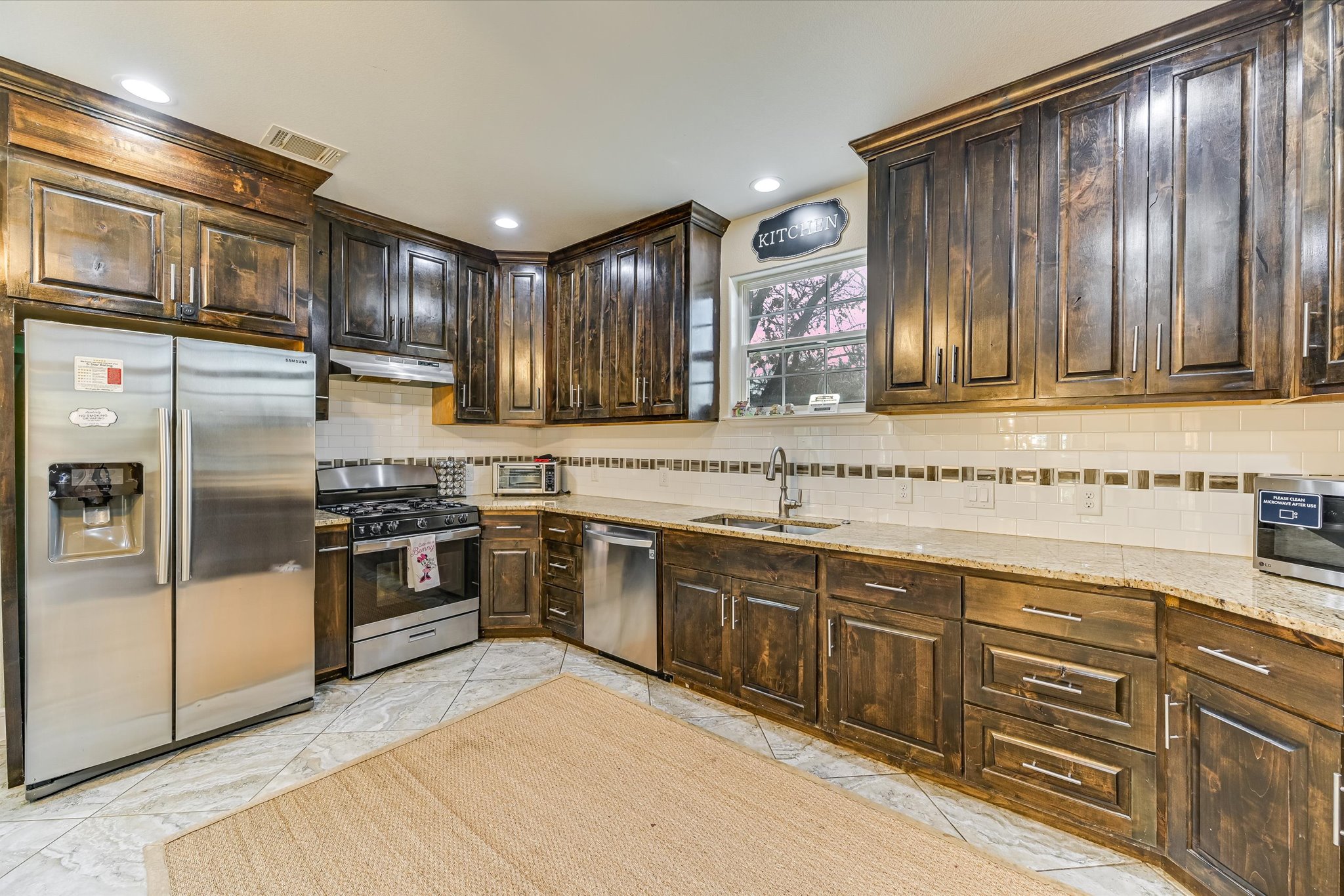 8400 Taylorsville Road Dale, TX 78616 - Photo 7 of 38 Kitchen featuring dark wood finish cabinets, stainless steel appliances, backsplash, and light stone countertops