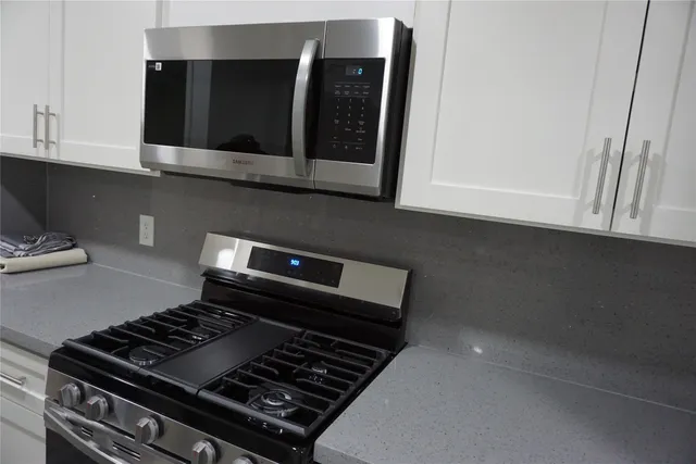 a close view of a stove a microwave and cabinets