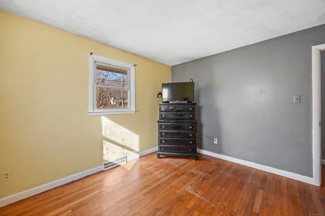 a view of a room with wooden floor and a window