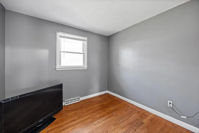 a view of an empty room with closet and a window